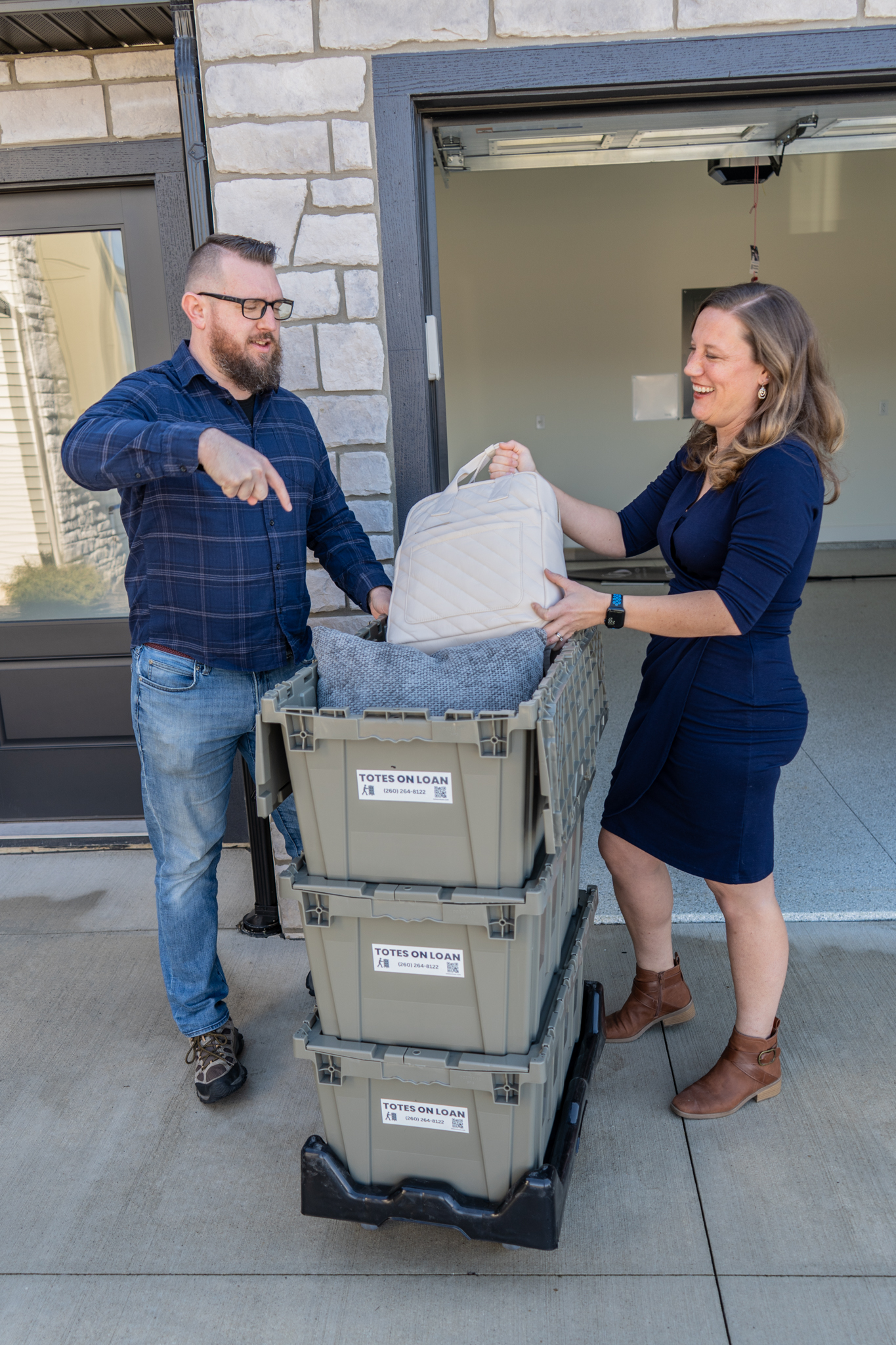 Couple laughing while packing a Totes on Loan moving tote